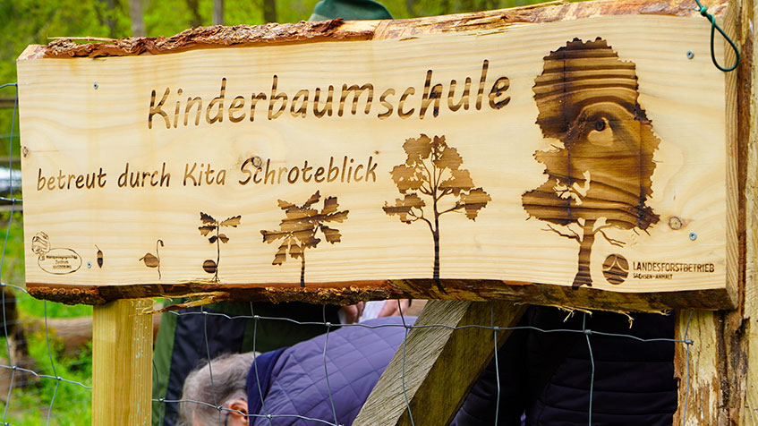 Orientierungstafel aus Holz mit der Beschriftung Kinderbaumschule